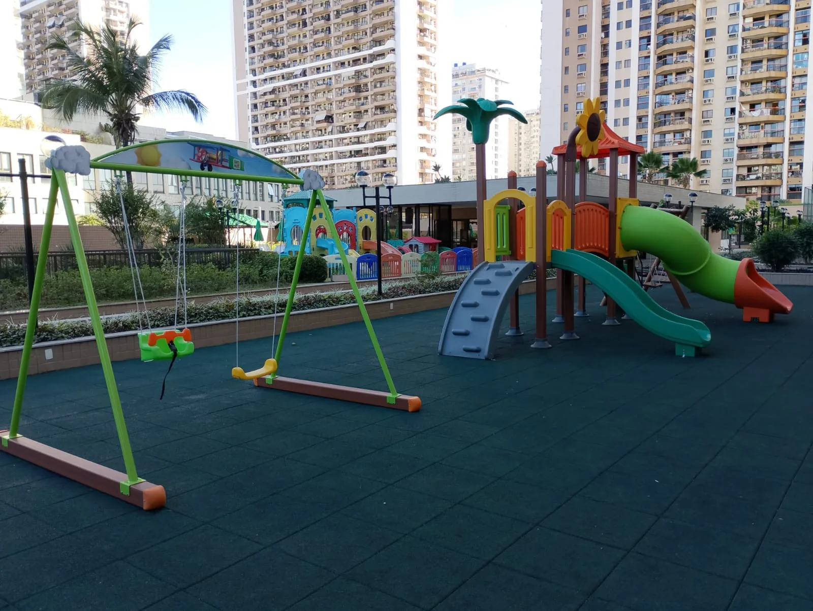 Playground e balanço instalados sobre piso emborrachado na área de lazer de um condomínio no Rio de Janeiro