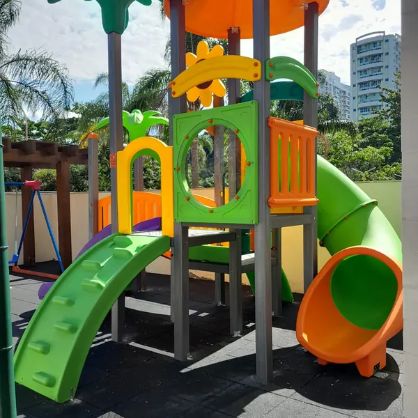 Playground com telhado laranja e escorregadores verdes no Condomínio Aloha, Recreio