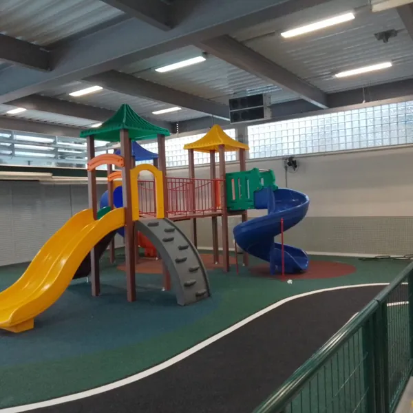 Playground coberto com escorregador amarelo e parede de escalada no Santo Inácio, Botafogo