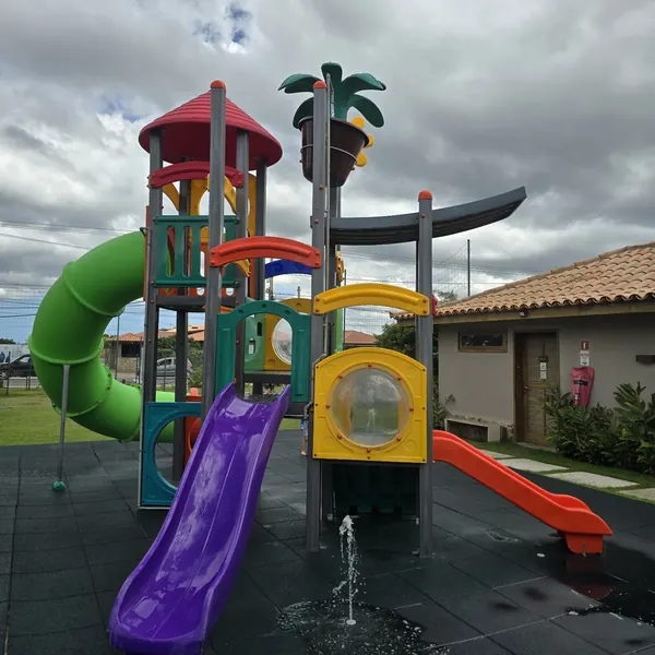 Torre de playground com escorregadores roxo e vermelho num restaurante em Búzios